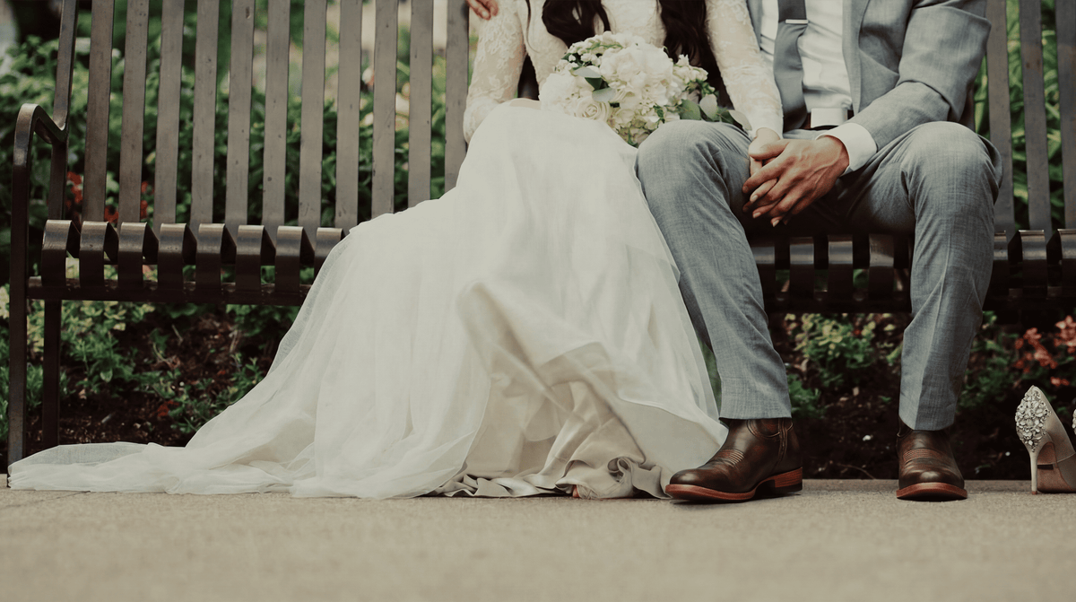 Groom wearing Chios No. 7 wedding cowboy boots seated next to bride outdoors