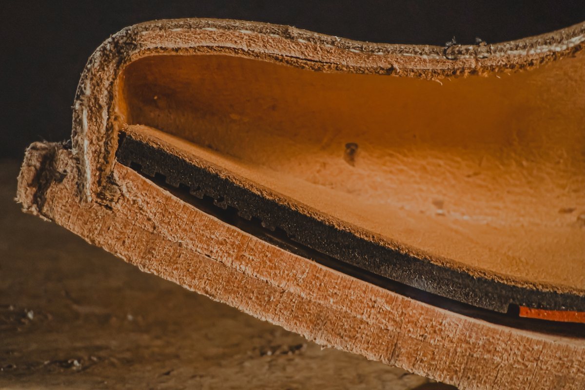 Macro of the cut toe: the welt stitched through the leather insole, with the comfort insole above it