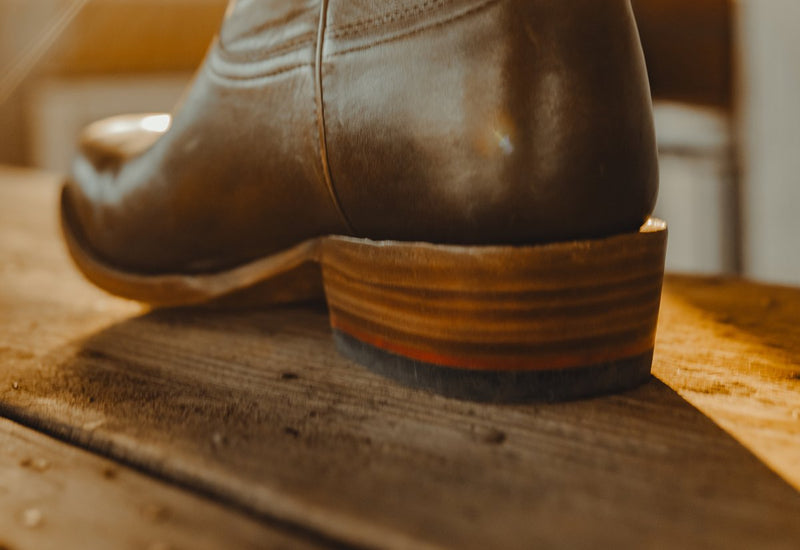 The stacked leather heel of a No. 2 on a wooden workbench